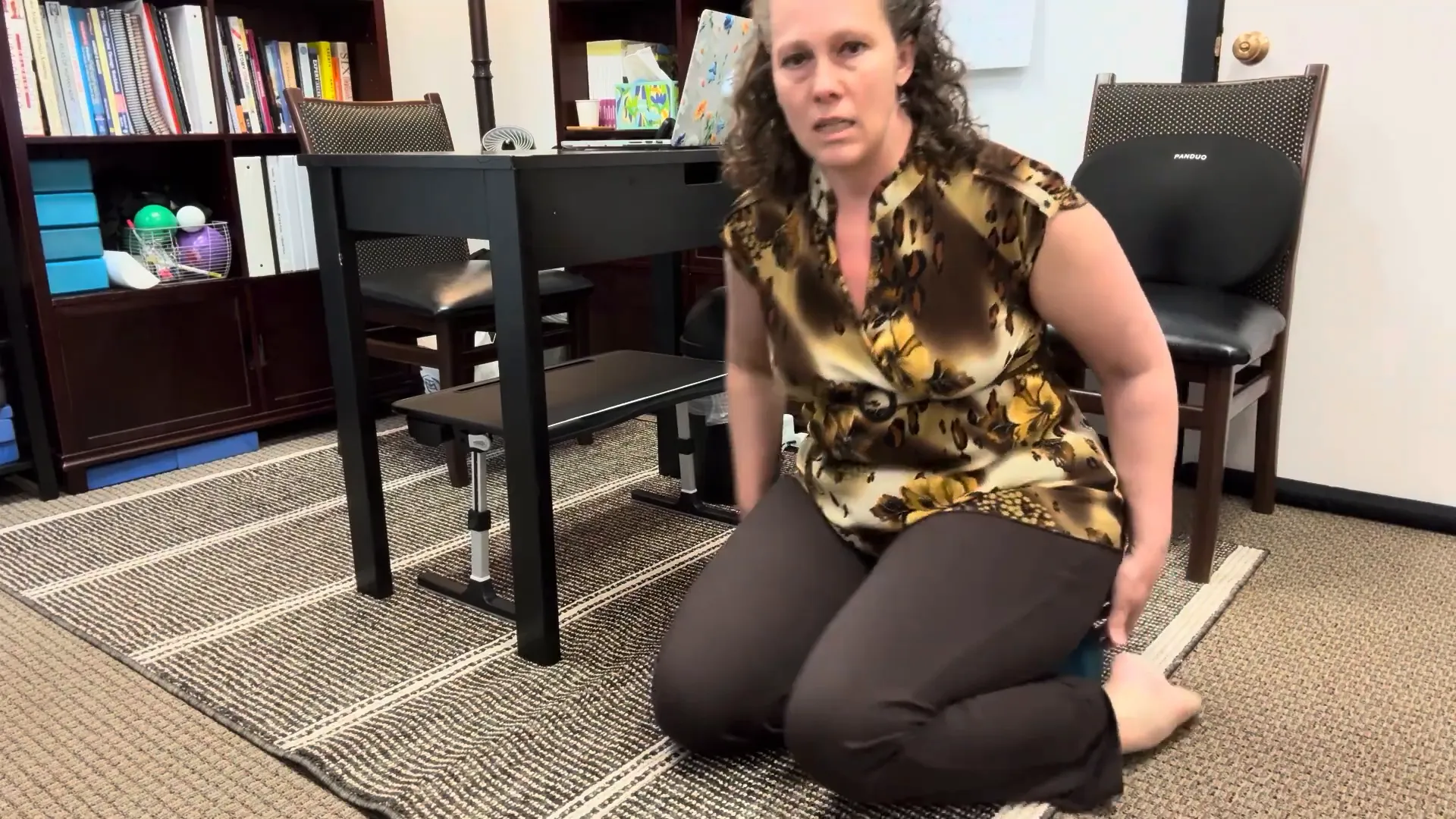 Sitting to one side on the cushion with one leg extended