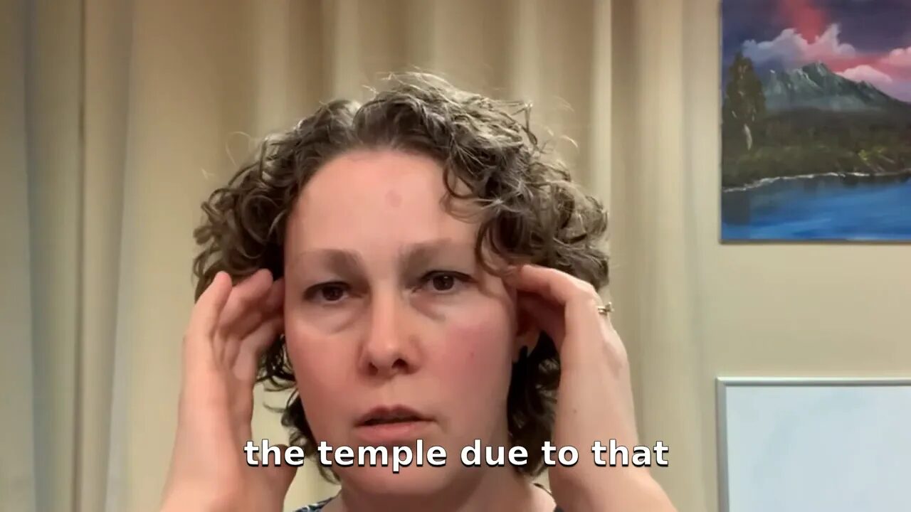 Fingertips pressing at the temple demonstrating temporalis massage