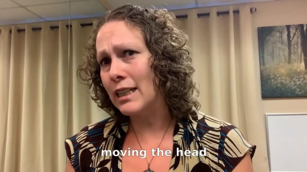 Presenter speaking with the subtitle 'moving the head' visible, illustrating the common habit
