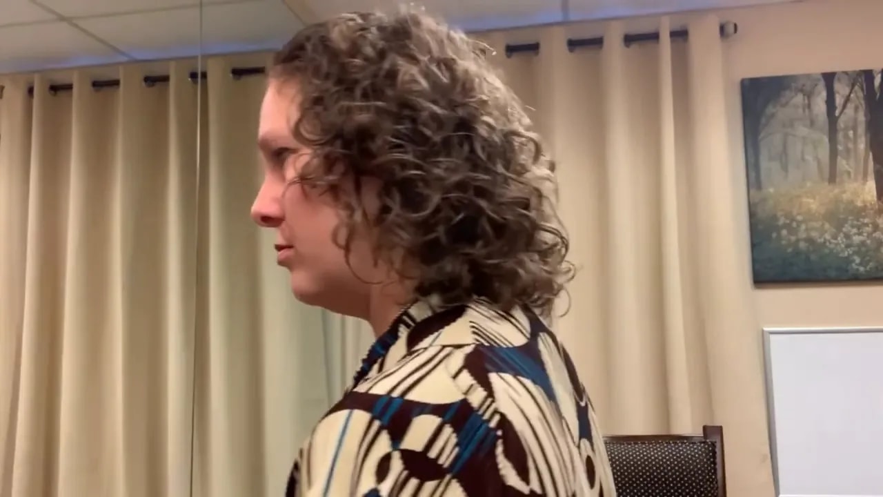 Side profile of a person at a desk showing the head and neck alignment against the shoulders.